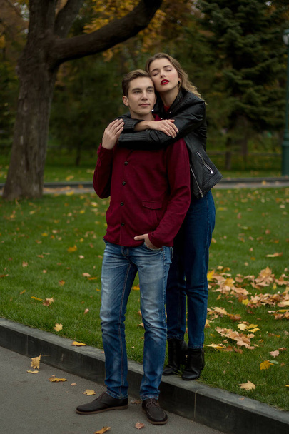 girl hugs a guy and smiles, autumn.hug from behind. portrait - Foto, Bild
