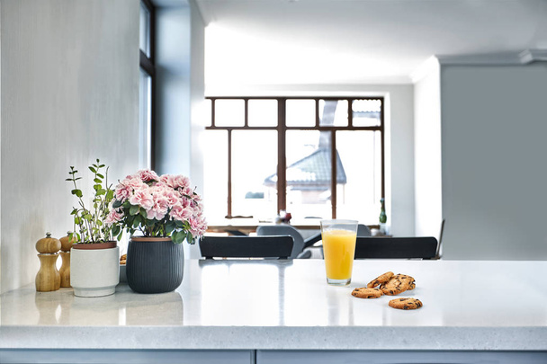 Sumo de laranja doce apetitoso e um copo de estar em uma mesa branca na cozinha para um café da manhã
. - Foto, Imagem