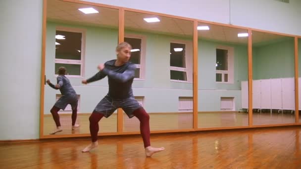 Aynanın önünde spor salonunda dans elemanları ile dövüş sanatları hileler erkek savaşçı gerçekleştirir - Video, Çekim