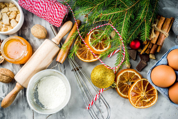 Vánoční zimní pečení koncept, přísady pro výrobu cukroví, pečení, koláče. Sušené plátky pomeranče, koření, nádobí, pohled shora šedý mramor pozadí kopie prostoru - Fotografie, Obrázek