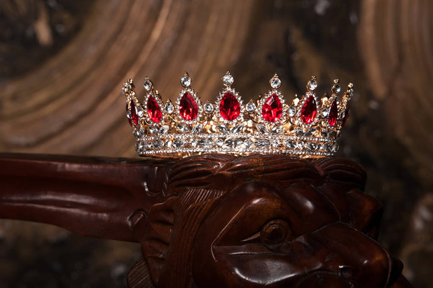 Королевская драгоценность корона с рубинами на темном деревянном фоне
 - Фото, изображение