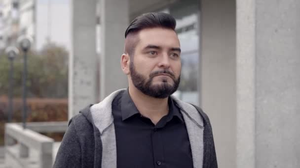 Young man in casual wear walking on street - Video, Çekim