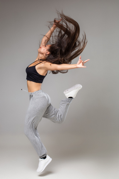 Танцовщица в стиле модерн позирует на фоне студии. Хип-хоп, джаз-фанк, танцевальный зал
 - Фото, изображение