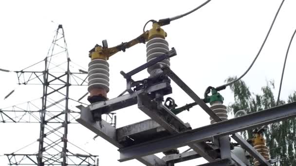 Elektrische onderstation apparatuur: elektriciteit transmissielijn, aardingsschakelaar. Frame. Aardingsschakelaar en een lijn van de macht op de hemelachtergrond. - Video