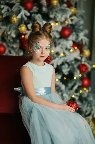 Beautiful little lady in Christmas decorations interior - Фото, изображение