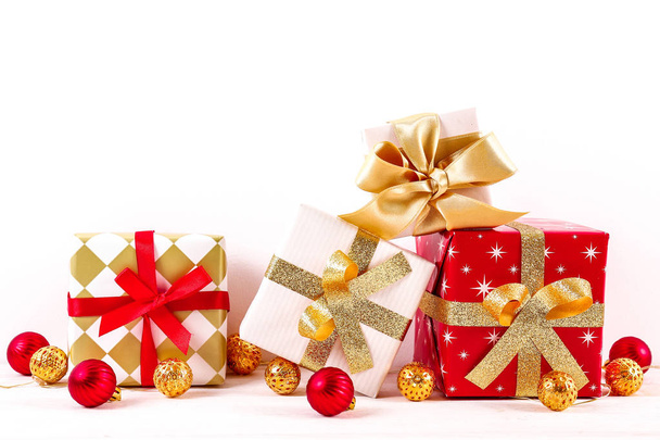Composition festive minimaliste avec cadeaux enveloppés, boules de Noël mattes colorées. Fantaisie belle décoration pour sapin de Noël. Arrière-plan, espace de copie, gros plan, vue de face
. - Photo, image