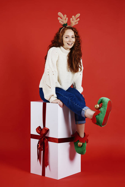 Porträt eines Mädchens mit riesigem Weihnachtsgeschenk bei Studioaufnahmen - Foto, Bild