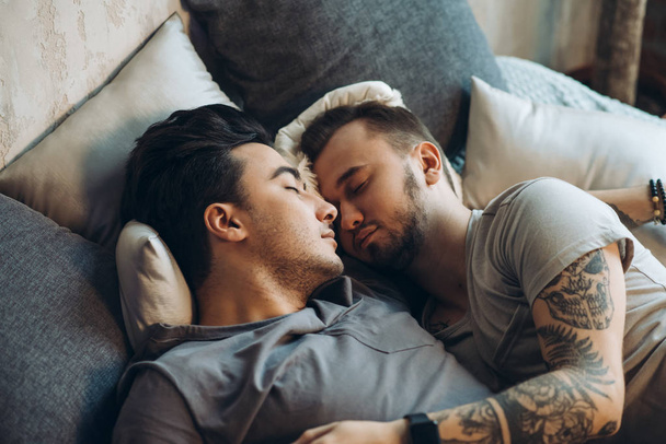 A homosexual couple on bed in studio with loft interior - 写真・画像