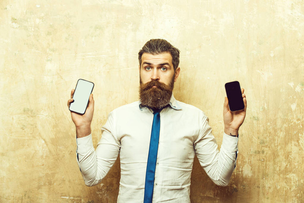 hipster or bearded man compare mobile phone and smartphone - Fotoğraf, Görsel