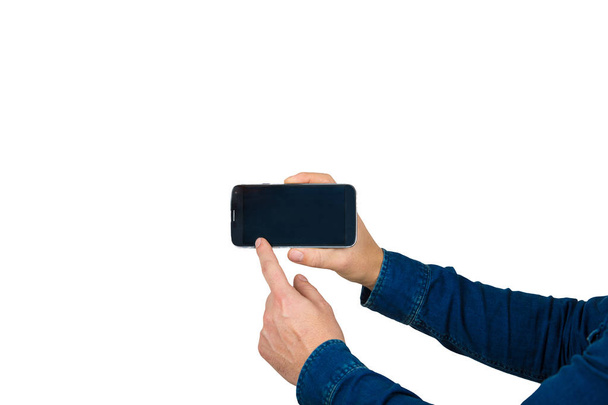 Primer plano de manos de hombre joven sosteniendo un teléfono inteligente, presentación de nueva tecnología señalando el dedo en la pantalla táctil
. - Foto, Imagen