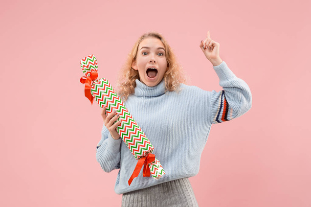 The surprised woman with big colorful gift box. Soft colors. Christmas, birthday, Valentine day, presents. Studio portrait over pink background - Fotó, kép