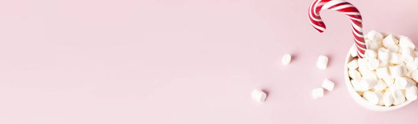 Natale nuovo anno bere, tazza bianca con marshmallows e canna caramella nella neve su sfondo rosa Flat Lay copia spazio. Bevande tradizionali invernali. Celebrazione festiva dell'arredamento Festa di Natale 2019
 - Foto, immagini