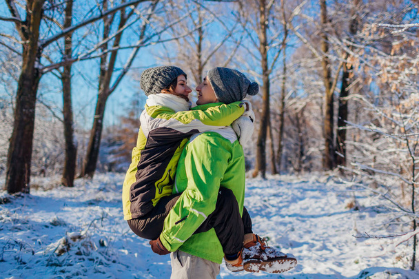 Coppia felice innamorata passeggiando e abbracciandosi nella foresta invernale. Un uomo con una ragazza. Giovani che si divertono
 - Foto, immagini