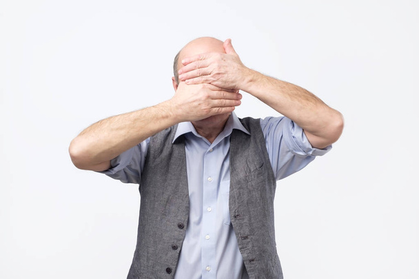 Homme âgé souffrant de sentiments douloureux griefing tête penchée vers le bas couvrant le visage avec des paumes
 - Photo, image