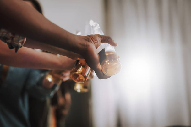 Young people clinking bottles of alcoholic drink - Fotó, kép