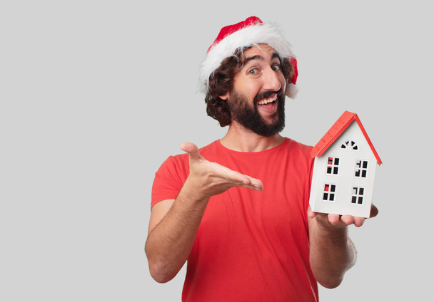 Young crazy man with house model. Christmas concept. - Photo, Image