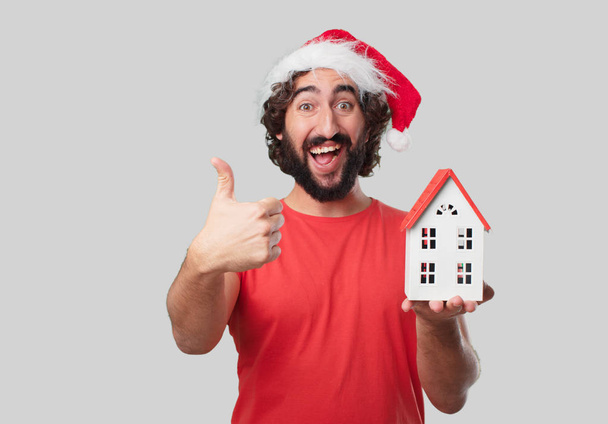 Young crazy man with house model. Christmas concept. - Photo, Image