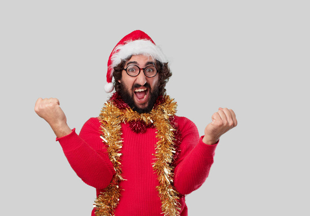 Young crazy man is gesticulating. Christmas concept. - 写真・画像