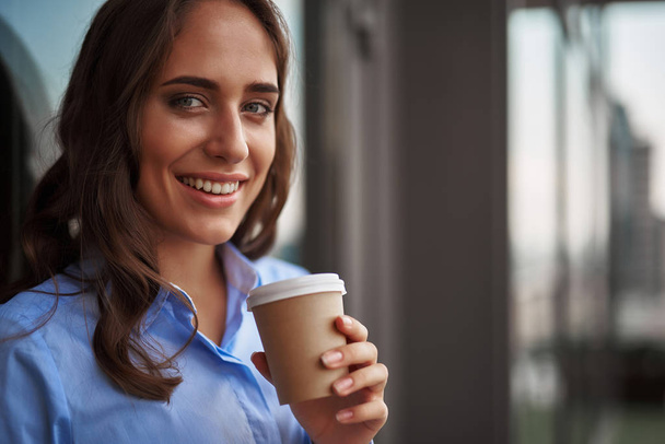 Female worker drinking coffee on office balcony - Φωτογραφία, εικόνα