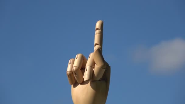 Drewniana ręka palec symbole koncepcja środkowy palec Zarejestruj w kurwa znaczenie gestu lub fuck off, obracanie na tle nieba - Materiał filmowy, wideo