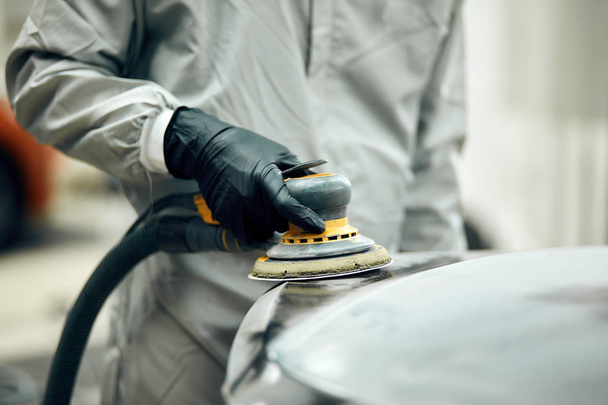 mechanic grinds car part for painting. Car body work auto repair paint after accident - Fotografie, Obrázek