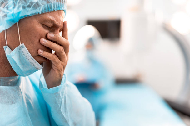 Exhausted doctor closing his eyes after having difficult day - Photo, image