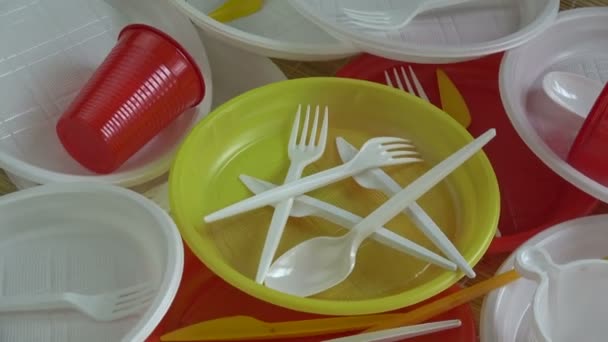 Forgó színes műanyag eldobható evőeszközök dishware háttér - Felvétel, videó