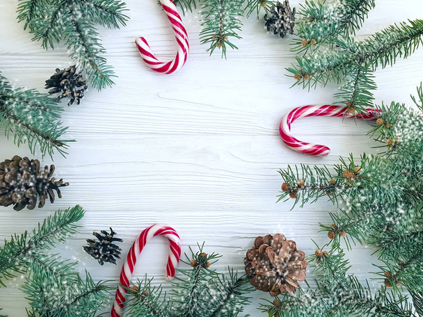 Rama de árbol de Navidad, piña, caramelo sobre un fondo de madera blanca
 - Foto, imagen