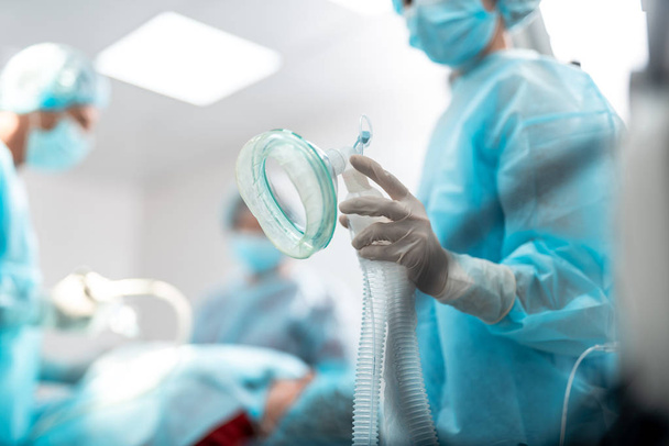 Mediziner mit Sauerstoffmaske im Operationssaal - Foto, Bild