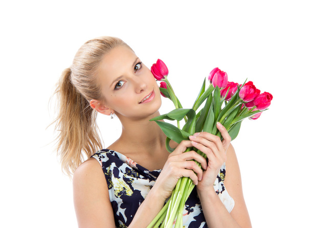 Young pretty woman holding a bunch of red tulips bouquet - Фото, зображення