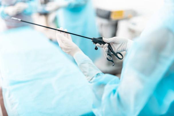 Nurse in sterile gloves holding laparoscopic instrument - Valokuva, kuva