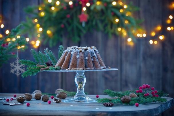 Christmas cake ahd fir branch  on dark wooden background - Zdjęcie, obraz
