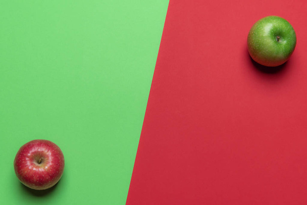 Sopra vista di un tavolo duotono con frutti di mela rossi e verdi in angoli opposti. Un sano contesto alimentare. Dieta vitaminica
. - Foto, immagini