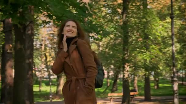Happy caucasian brunette female is smiling and walking in park, pure nature, sunlights, motion illustration, calm - Filmagem, Vídeo