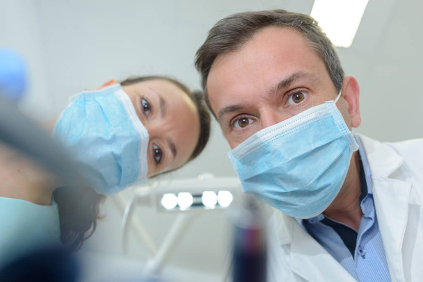 close-up portrait from bottom of male dentist and his assistant - Photo, Image