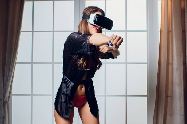 Beautiful woman wearing Lingerie using vr-goggles in bed. - Foto, imagen