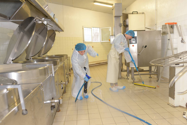 cleaners cleaning industrial kitchen floor - Foto, Bild