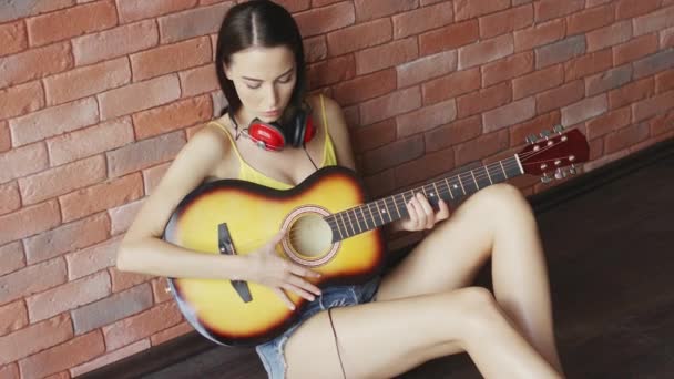 mujer con auriculares tocando la guitarra
 - Imágenes, Vídeo