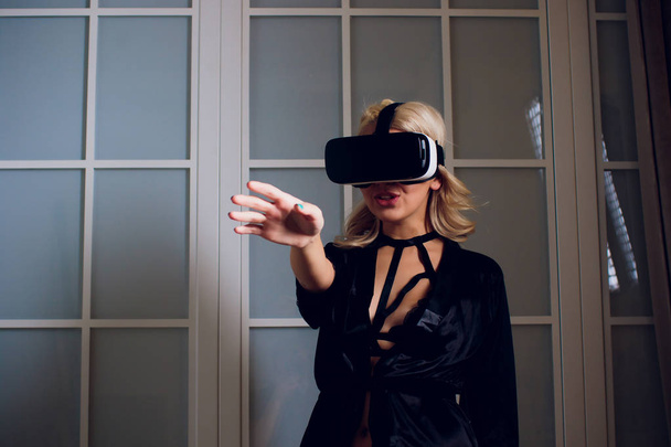 Beautiful woman wearing black Lingerie using vr-goggles. - Photo, Image