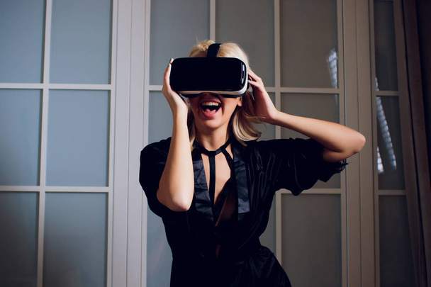 Beautiful woman wearing black Lingerie using vr-goggles. - Photo, image