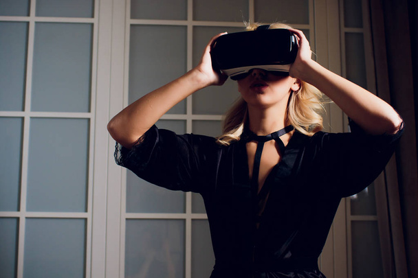 Beautiful woman wearing black Lingerie using vr-goggles. - Foto, Bild