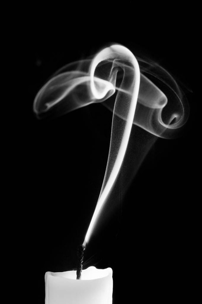 Smoke from a candle on a black isolated background. An interesting and weird smoke pattern - Photo, Image