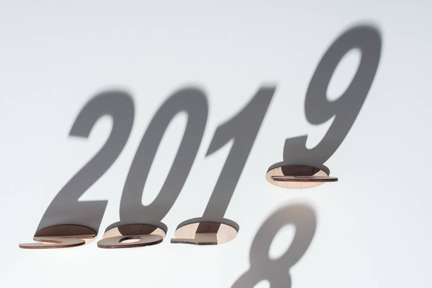 top view of wooden numbers with shadow on white background symbolizing change from 2018 to 2019 - Photo, image