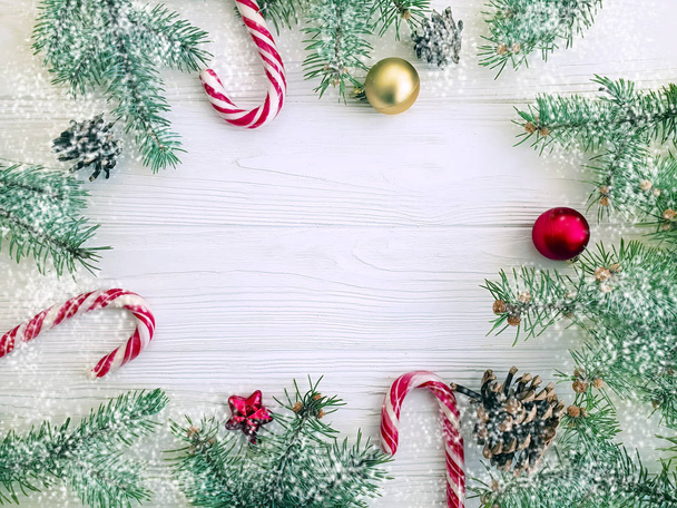 Boże Narodzenie drzewo gałąź, szyszka, cukierki na białym tle drewniane ramki, śnieg - Zdjęcie, obraz
