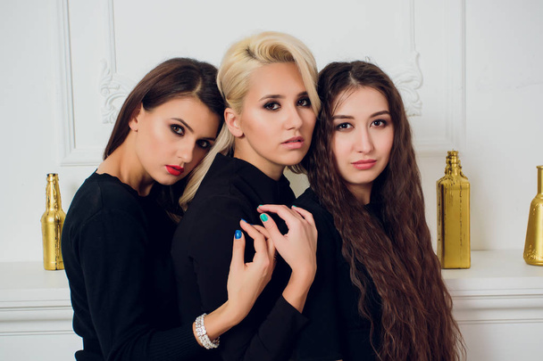 Three playful attractive young women white background. - Zdjęcie, obraz