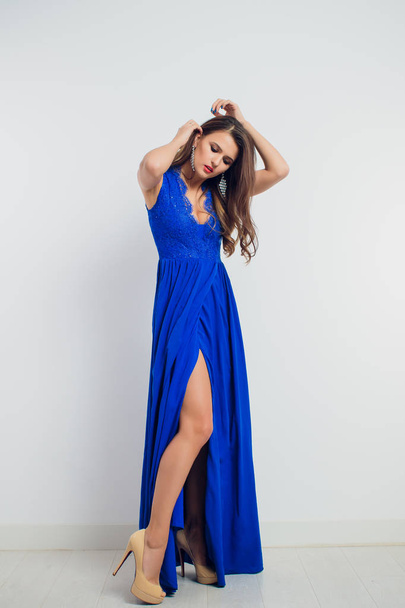 brunette beautiful young woman posing in blue dress. Glamour makeup. Long hair. Studio shot. - Photo, Image