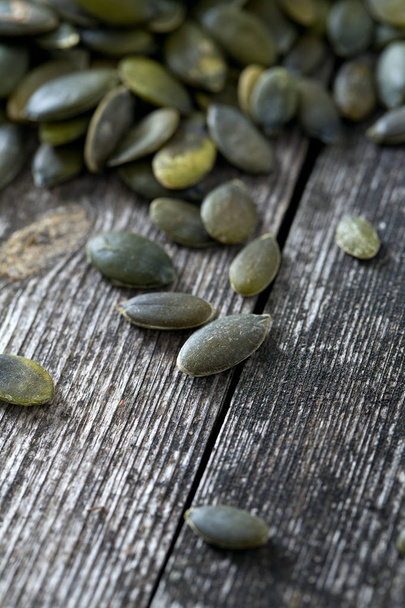 pumpkin seeds on wooden surface - Foto, Imagen
