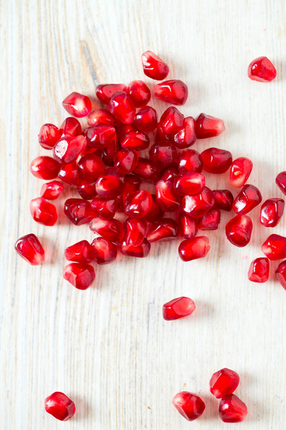 pomegranate seeds on wooden surface - 写真・画像