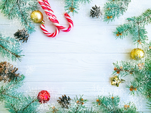 Rama de árbol de Navidad, piña, caramelo sobre un marco de fondo de madera blanca, nieve
 - Foto, imagen