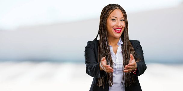 Ritratto di una giovane donna d'affari nera che si mette in contatto per salutare qualcuno o gesticolare per aiutare, felice ed eccitata
 - Foto, immagini